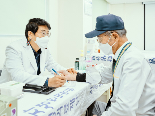 신민식 자생의료재단 사회공헌위원장이 연평도 주민을 문진하고 있다. 자생의료재단 제공.